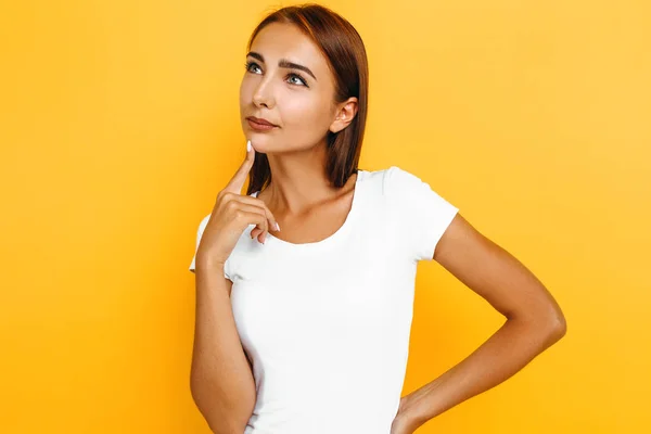 Sério pensativo jovem mulher pensando no fundo amarelo — Fotografia de Stock