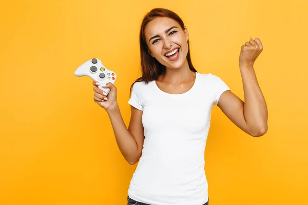Izgatott lány, egy fehér póló, játék egy videojáték a jo — Stock Fotó