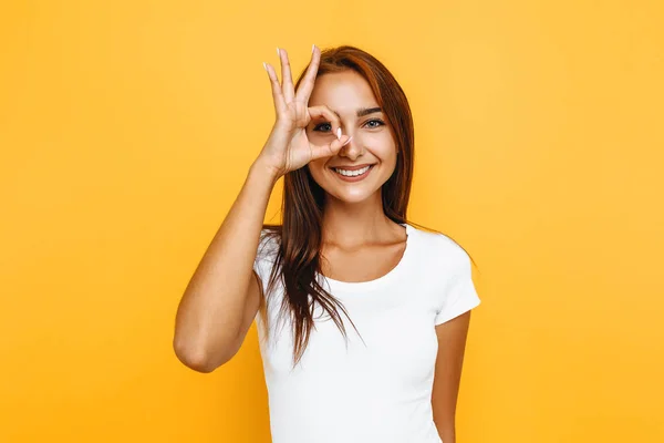 Junges fröhliches Mädchen zeigt null Geste auf gelbem Hintergrund — Stockfoto