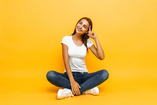 Menina Pensive em t-shirt branca no fundo amarelo com co — Fotografia de Stock