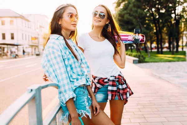 Dos niñas alegres en pantalones cortos, amigos posan de pie con —  Fotos de Stock
