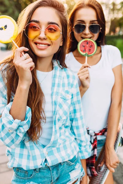 Jóvenes chicas divertidas con estilo con piruletas divertirse en la ciudad en —  Fotos de Stock