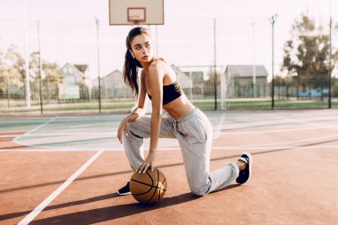 Çekici genç atletik kız, açık havada, bir basketba ile poz