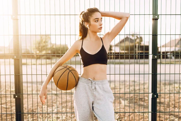 Junge athletische Mädchen, im Freien, posiert mit einem Basketball. Sport, — Stockfoto