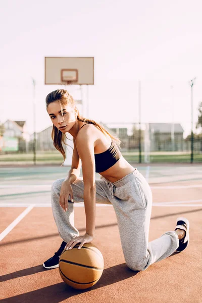 Atractiva joven atlética, al aire libre, posando con una basketba —  Fotos de Stock