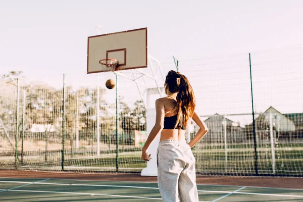 Schöne junge athletische Mädchen werfen einen Ball in den Ring auf der — Stockfoto