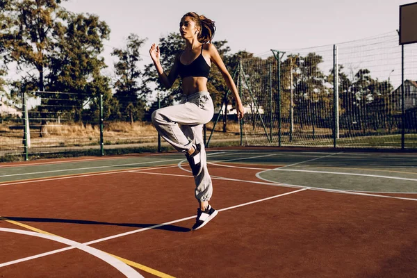 Attraktive junge Sportlerin, die im Freien trainiert und Hea trägt — Stockfoto