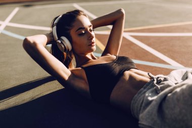 Genç güzel güçlü kız açık havada abs egzersizleri yapıyor. Yan görünüm