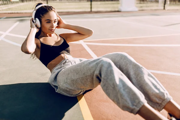 스포츠 운동을 하는 아름 다운 젊은 운동 피트니스 여자의 이미지, 헤드폰으로 음악을 듣고 아침 야외. — 스톡 사진
