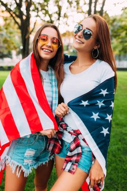 Amerikan bayrağı celebra tutan iki güzel kız portresi
