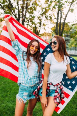 Amerikan bayrağı celebra tutan iki güzel kız portresi