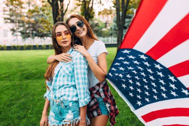 Amerikan bayrağı celebra tutan iki güzel kız portresi