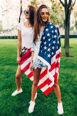 Yaz aylarında Parkta poz, Bir Amerikan bayrağı ile iki şık çekici kız