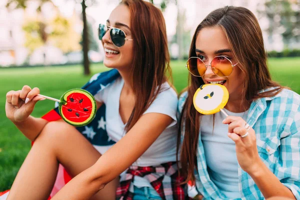 Chicas divertidas jóvenes con piruletas, mueca y divertirse en la ci —  Fotos de Stock