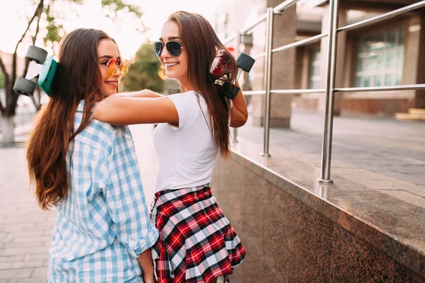 Due belle ragazze alla moda camminano per le strade della città con sk — Foto Stock