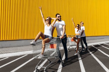 Mutlu gençlerin bir grup, alışveriş arabaları üzerinde eğlenmek, kurtulmak