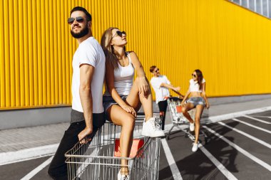 Mutlu gençlerin bir grup, alışveriş arabaları üzerinde eğlenmek, kurtulmak