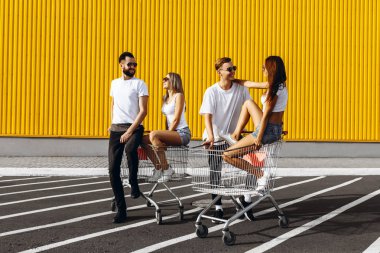 Mutlu gençlerin bir grup, alışveriş arabaları üzerinde eğlenmek, kurtulmak