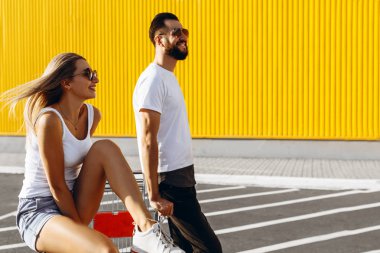 Bir adam ve bir kız süpermarket yakınında bir araba sürme eğlenin,