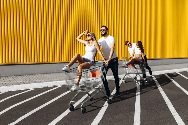 Un groupe de jeunes en t-shirts blancs, promenade amusante sur des chariots nea — Photo