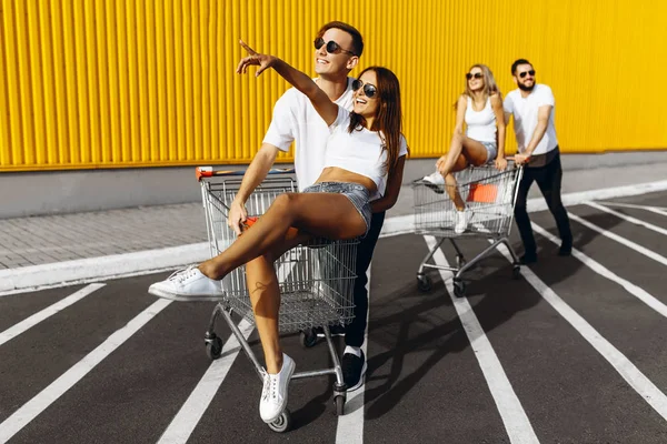 Un groupe de jeunes en t-shirts blancs, promenade amusante sur des chariots nea — Photo