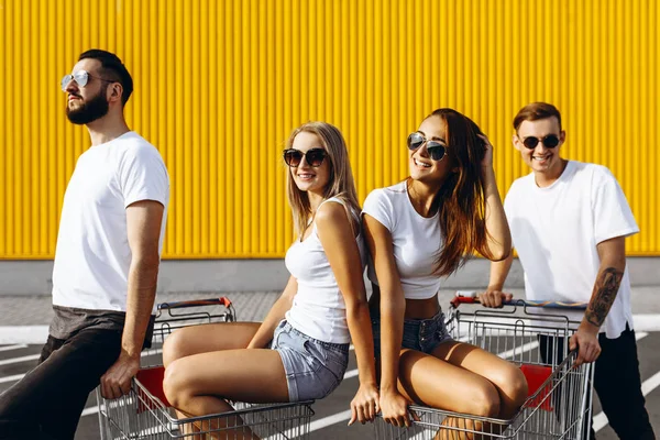 Skupina šťastných mladých lidí, užívala si nákupních vozů, zbavila se — Stock fotografie