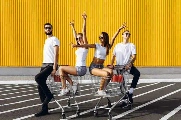 Um grupo de jovens felizes, se divertindo em carrinhos de compras, livrar — Fotografia de Stock
