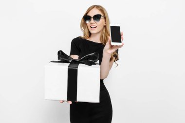 Siyah elbiseli çekici bir genç kız bir hediye tutan bir 