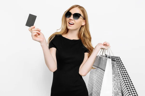 Jonge vrouw in zwarte jurk en zonnebril, met creditcard en — Stockfoto