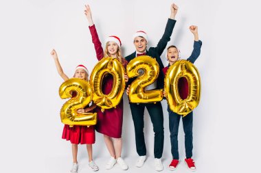 Noel Baba şapkası takan, eğlenen, çocuklu mutlu bir aile.