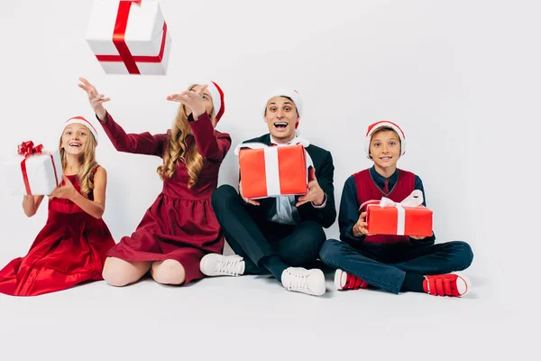 Família feliz Natal com crianças vestindo chapéus de Papai Noel sentado — Fotografia de Stock