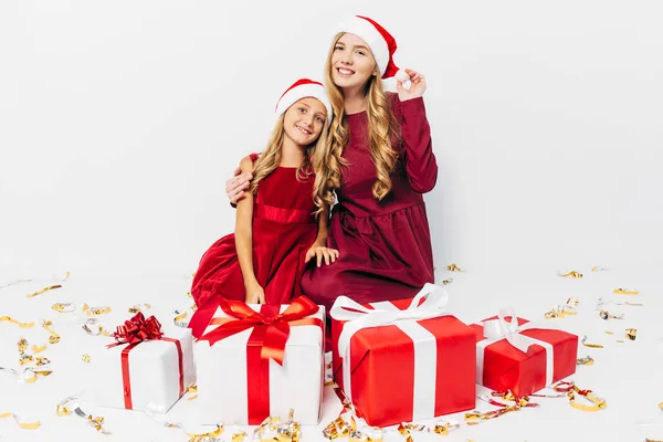 Молода Різдвяна сім'я, мама і дочка в капелюхах Санта, що мають — стокове фото