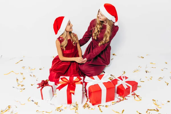 Een jonge kerst familie, moeder en dochter in Santa hoeden, besteden — Stockfoto