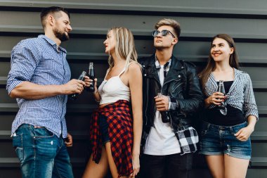 Bir grup genç şık arkadaş, kızlar ve erkekler birlikte poz veriyorlar.