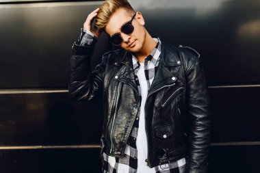 Güneş gözlüğü takan, deri ceketli güzel bir adam.