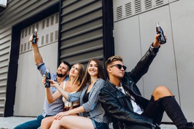 Genç arkadaşlar yürür, öğrenciler eğlenir ve içki içerler.