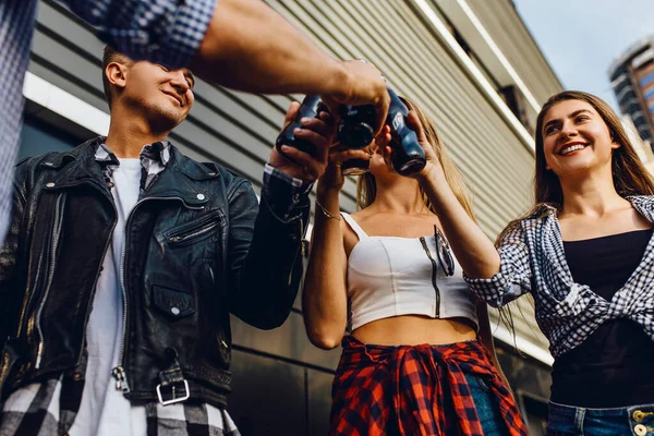 一群朋友、女孩和男人一起在城市的黑墙边散步，玩的开心，喝酒 — 图库照片