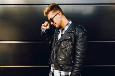 Güneş gözlüğü takan, deri ceketli güzel bir adam.