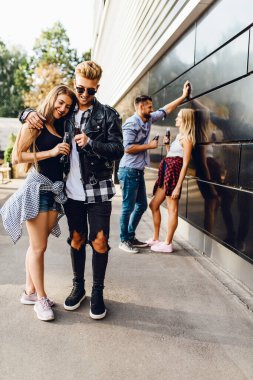 Genç şık arkadaşlar şehirde dolaşıyor, öğrenciler eğleniyor.