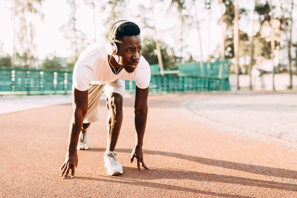 Un giovane atletico afroamericano si trova all'inizio del tapis roulant allo stadio — Foto Stock