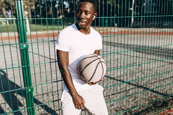 Strong African American with a basketball in the stadium