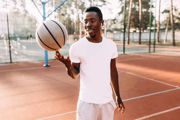 Giocatore di basket gira una pallacanestro, allenamento mattutino allo stadio — Foto Stock