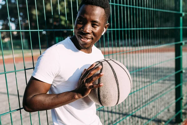 Strong African American with a basketball in the stadium