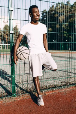 Stadyumda basketbol topu olan güçlü bir Afrikalı Amerikalı.