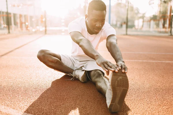 Athlétisme afro-américain faire des exercices d'étirement, se préparer pour l'entraînement matinal au stade — Photo