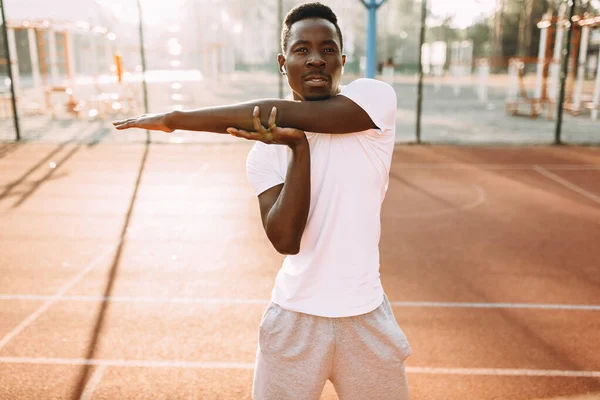 Athlétisme afro-américain faire des exercices d'étirement, se préparer pour l'entraînement matinal au stade — Photo