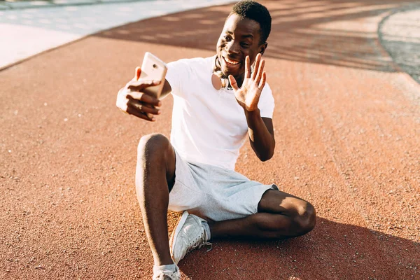 Afro-Américain repose après une séance d'entraînement matinale prend un selfie sur un smartphone — Photo