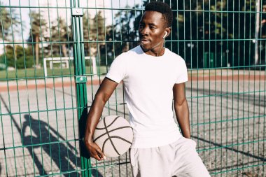 Stadyumda basketbol topu olan güçlü bir Afrikalı Amerikalı.