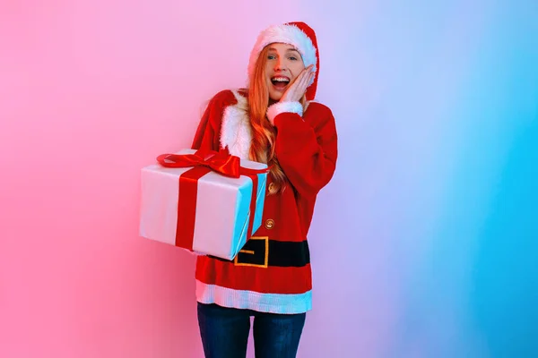 Happy excited woman in Santa hat with gift box on background with neon light — Stock Photo, Image