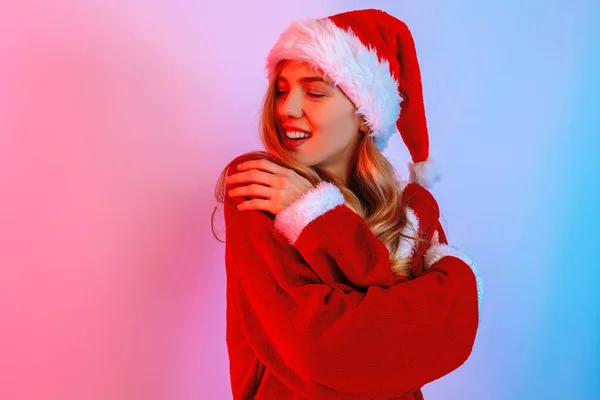 Jolie jeune femme dans le chapeau Santa posant sur fond de néons — Photo